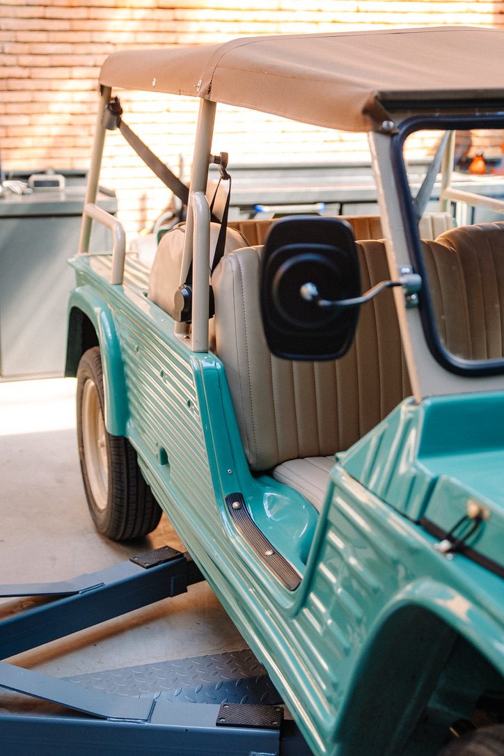 Tan leather seats inside a turquoise Méhari, golden hour light through the canvas top