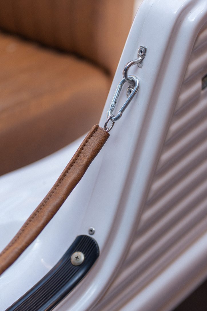 Leather canvas strap with polished chrome carabiner clip on a Méhari panel